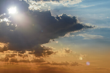 Naklejka na ściany i meble Dramatic sunrise or sunset, the sun's rays shine through the clouds
