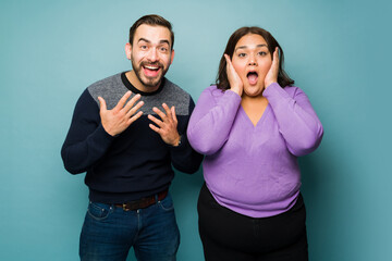 Excited beautiful couple looking surprised