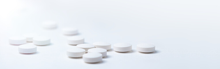 White medical pills placed on a white background