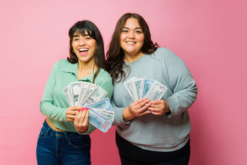 Beautiful best friends showing a lot of money