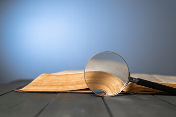 Book and magnifier on wooden table