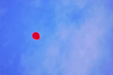 青空に登っていく一つの赤いゴム風船