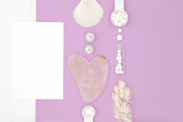 Equipment for self-massage, facial skin care and spa, pink gouache scraper, cream and vitamin pills, postcard for text on white and colored background