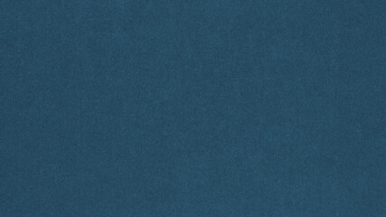 Dark blue colored paper texture. Tinted background. Textured wallpaper. Large patterned surface. Fibers and irregularities are visible. Top-down