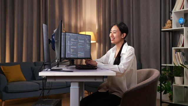 Asian Woman Programmer Smiling And Crossing His Arms While Creating Software Engineer Developing App, Program, Video Game On Desktop Computer At Home
