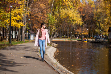 Portrait of a young beautiful brunette woman in autumn park