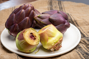 Heads of raw fresh purple romanesco artichoke vegetable heads and pilled hearts