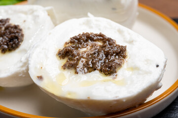 White balls of Italian soft cheese Mozzarella di Bufala Campana stuffed with black truffles mushrooms