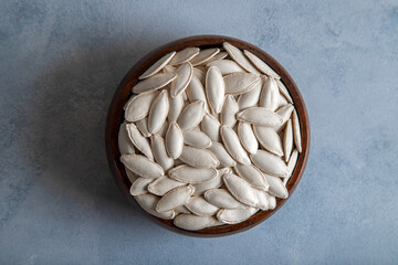 A bowl full of pumpkin seeds on biright background
