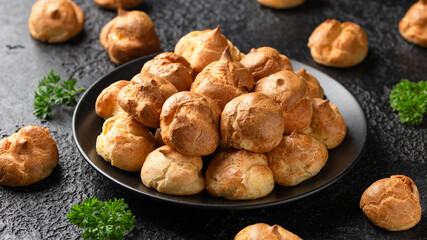 Savoury profiteroles stuffed with Molten cheddar cheese sauce, party food concept