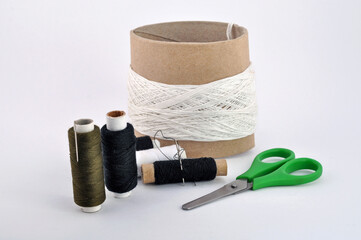 Sewing threads, needles and scissors are isolated on a white background