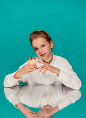 Studio portrait of a girl at a table with sweets