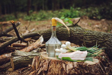 Still life with vodka on a stump. National lunch of Ukrainian loggers. A bottle of moonshine,...
