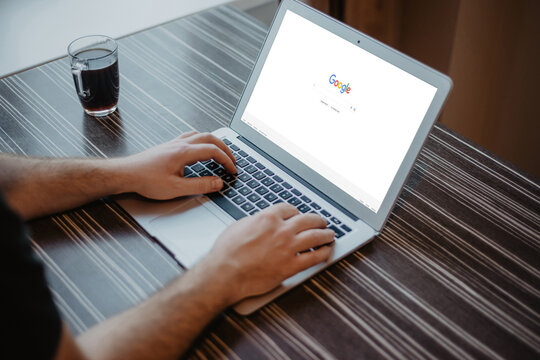 Riga, Latvia - January 29, 2023 Man Using Laptop Browsing Google Website