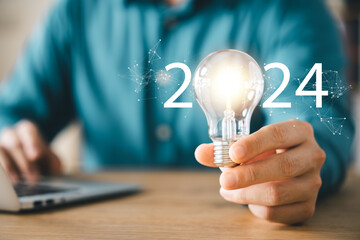 2024 creative concept, business man holding light bulb 2024 numbers, 2024 trend leader, setting...