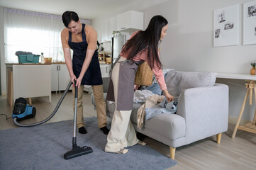 Happy young Asian couple cleaning home together, healthy lifestyle concept