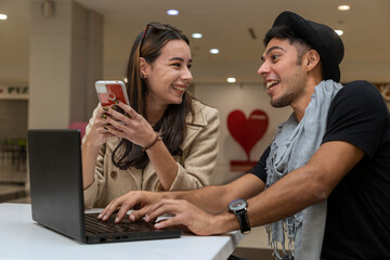 Young latin couple plan their Valentine's Day trip. Concept online shopping, Valentine's Day