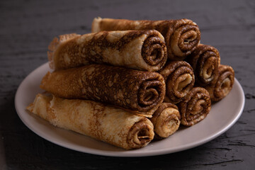 photo thin pancakes lying in a row on a plate