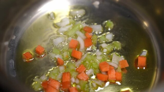 Healthy vegetable food. Carrots celery onions are frying cooking in the EVO olive oil in a pan.
