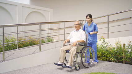 Old elderly disabled Asian patient or pensioner and a nurse using wheelchair in nursing home in hospital. Senior people lifestyle activity recreation. Health care therapy in garden park.