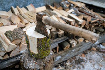 Ax stuck in a log. A pine log cut in half. Preparation of firewood.