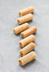 Small sweet waffle rolls. Light grey background