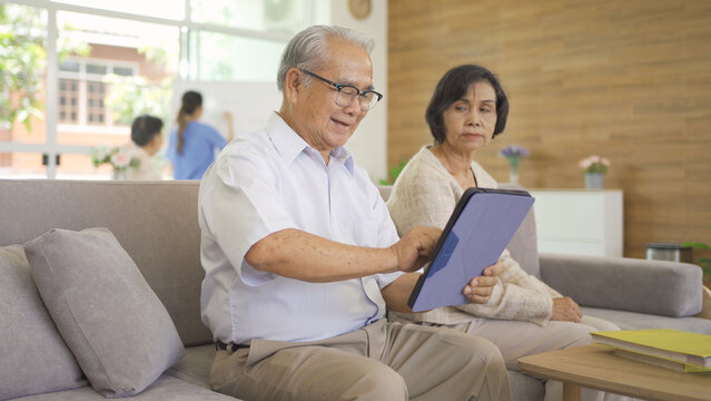 Frustrated angry Asian couple dissatisfied or fight with her technology device, couple senior elderly patient person in nursing home in medical healthcare. People lifestyle. Family wife and husband