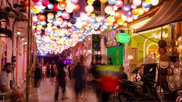 timelapse landscape night view with light illumination on the colonial architecture building with crowded people in Phuket Festival 2023 night time