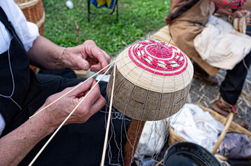 hands busy building a basket by weaving branches