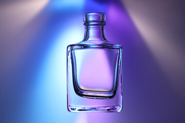 Boccetta in vetro trasparente, isolata, in controluce su fondo colorato