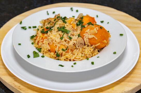 Traditional recipe for pequi (Caryocar Brasiliense) with rice and chicken in selective focus.