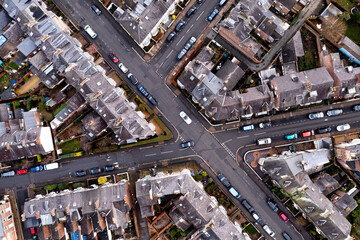 Aerial view directly above the rooftops and road junction in a typical English suburban neghbourhood