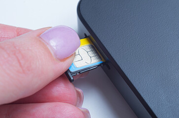 Woman inserting sim card into portable mobile wifi router. To connect to the internet for online...