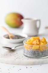 Chia pudding parfait topped with diced mango, ready for eating.