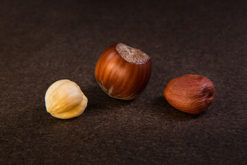 hazelnuts peeled and inshell on a dark background