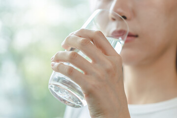 Clean freshwater concept. Woman drink mineral water in the morning for good health.