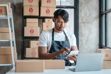 Handsome business sme owners in apron with delivery box package stock warehouse preparing after received online order from customer in social media in laptop, he is influencer.