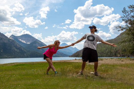 couple being silly in the mountains in front of lake