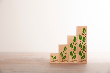 Konzept Balkendiagramm aus Holzwürfeln mit Planzenelementen in einem hellen Raum mit Holzfußboden