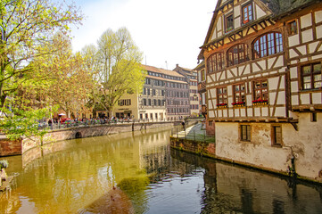 Fototapeta na wymiar Ancient wood-framed traditional German French houses in Strasbourg at sunset colors, historical downtown of the city