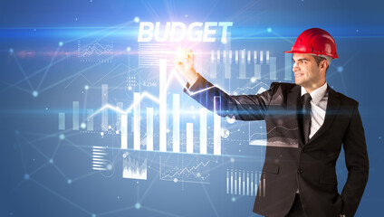 Young businessman with helmet drawing on virutal screen