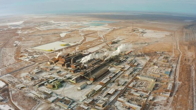 Aktobe Plant of Chromium Compounds. Chrome factory with smoking chimneys in cold winter in snow drone view.
