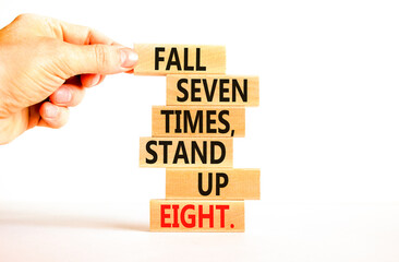 Stand up symbol. Concept words Fall seven times stand up eight on wooden blocks. Beautiful white table white background. Businessman hand. Business stand up concept. Copy space.