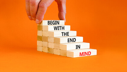 Begin in end of mind symbol. Concept words Begin with the end in mind on wooden blocks. Beautiful orange table orange background. Businessman hand. Business begin in end of mind concept. Copy space. - obrazy, fototapety, plakaty