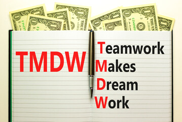 TMDW Teamwork makes dream work symbol. Concept words TMDW Teamwork makes dream work on white note beautiful white background. Dollar bills. Business TMWD teamwork makes dream work concept. Copy space.