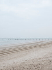 Pontile deserto in una giornata d'inverno con bassa marea, sulla spiaggia vuota di Rimini, Italia. 