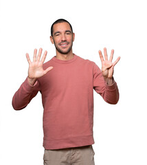 Happy young man doing a number nine gesture with his hands