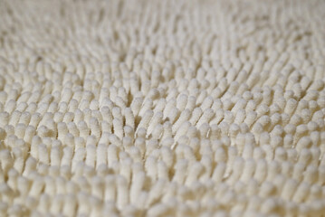 Bath mat close-up. The texture of the carpet with a long and fluffy pile. Shallow depth of field.
