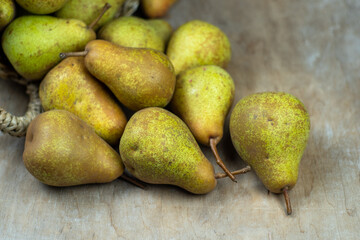 Pears in basket on a wooden background. Fruit harvest. Autumn still life. Pear variety Bera Conference. Vitamin food.