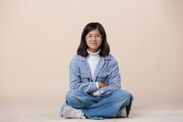 Mexican 12 year old girl sitting on the floor looking at camera
